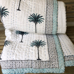 Blue Palms on white, slightly padded cotton quilt.