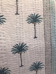 Blue Palms on white, slightly padded cotton quilt.